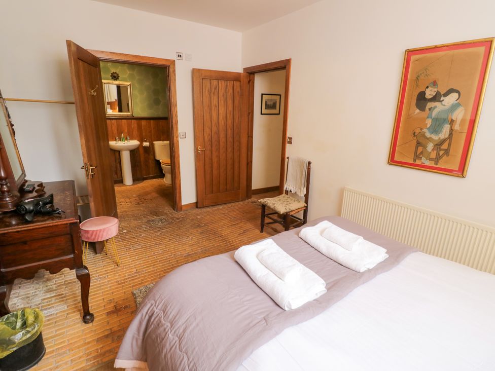 A bedroom with a bed and a dressing table at Chetwynd Lodge Ingestre near Great Haywood