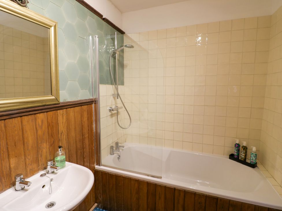A bathroom with a bath, shower, sink, and mirror at Chetwynd Lodge Ingestre near Great Haywood