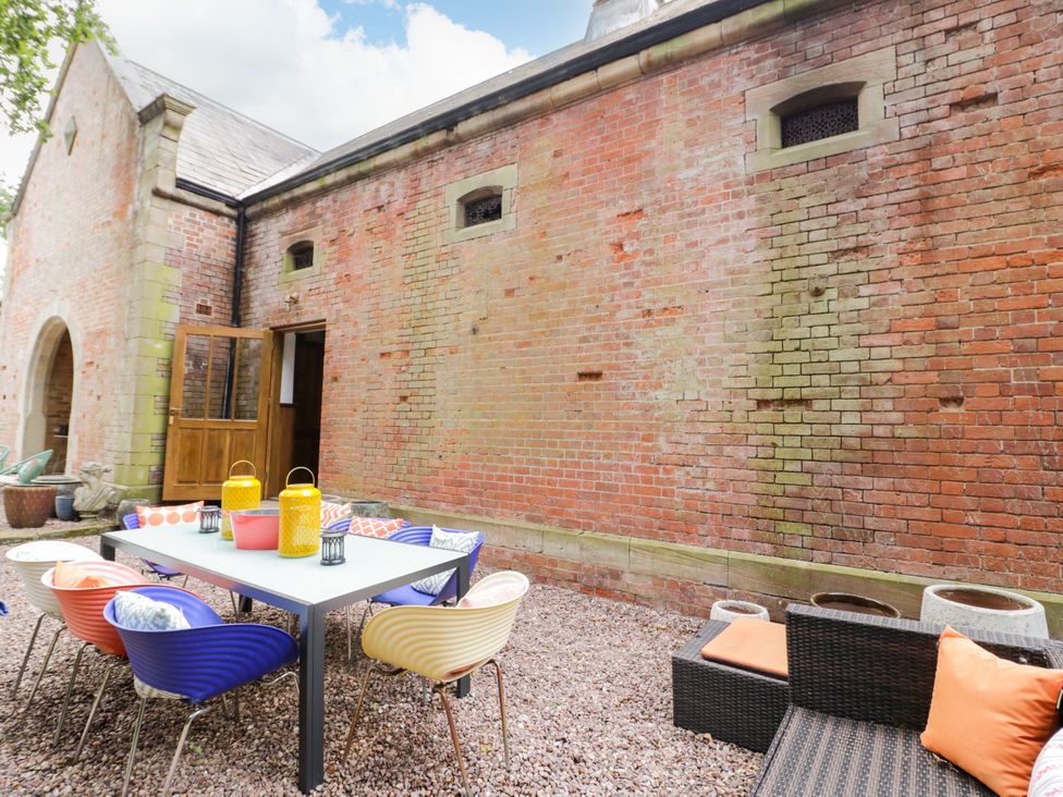 A garden with a table and chairs at Chetwynd Lodge Ingestre near Great Haywood