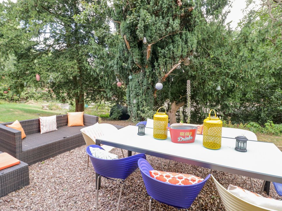 A garden with an outdoor table and chairs at Chetwynd Lodge Ingestre near Great Haywood