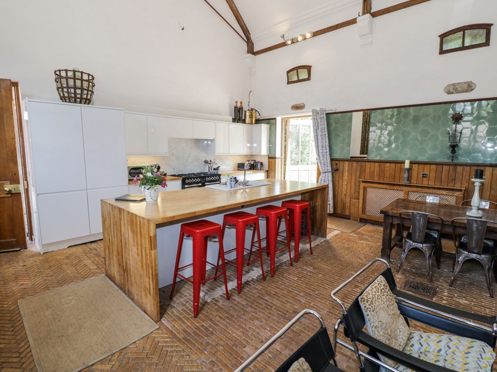 A kitchen with an island and stools at Talbot Lodge Ingestre near Great Haywood
