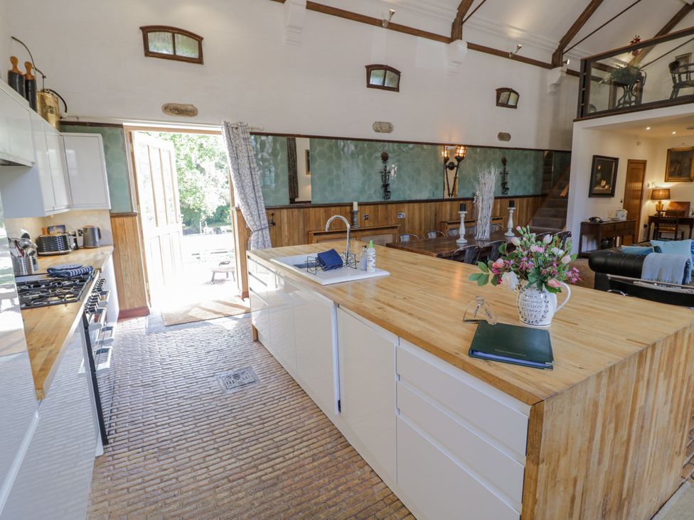 A kitchen with a central island and a view to the outdoor at Talbot Lodge in Ingestre near Great Haywood