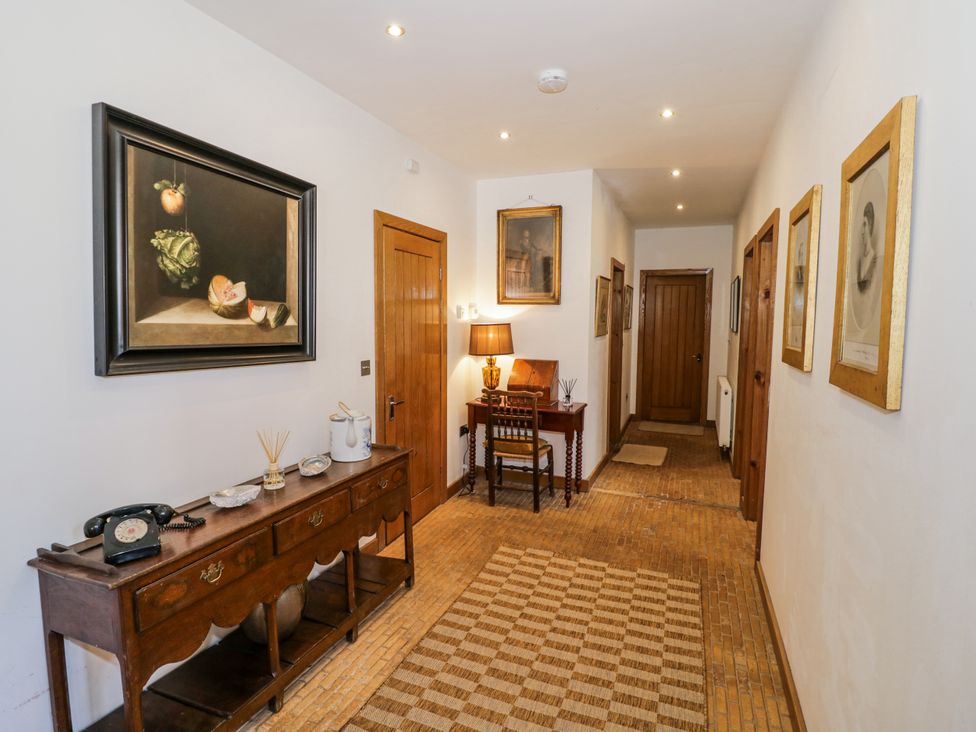 A hallway with a table and artworks at Talbot Lodge Ingestre near Great Haywood
