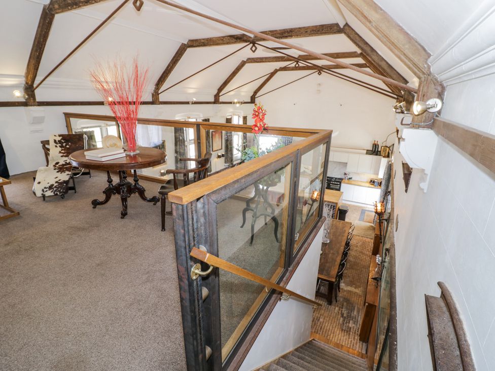 A loft area with a dining table and kitchen visible at Talbot Lodge Ingestre near Great Haywood