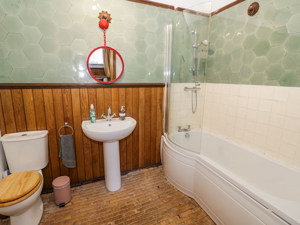 A bathroom with a bathtub, sink, and toilet at Talbot Lodge Ingestre near Great Haywood