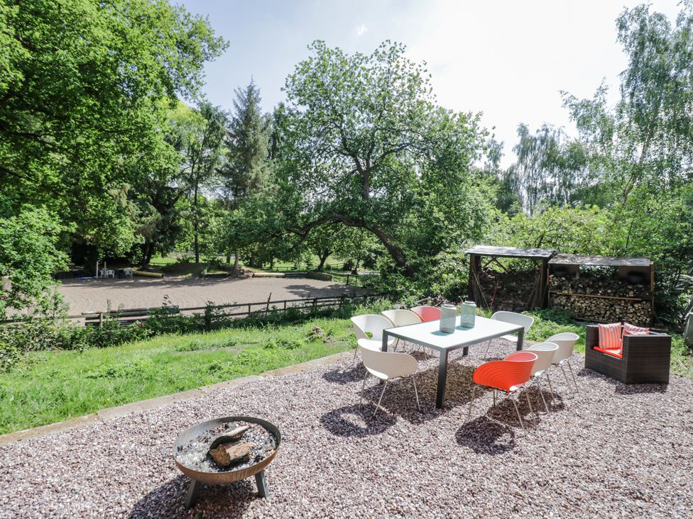 An outdoor seating area with a table and fire pit at Talbot Lodge Ingestre near Great Haywood