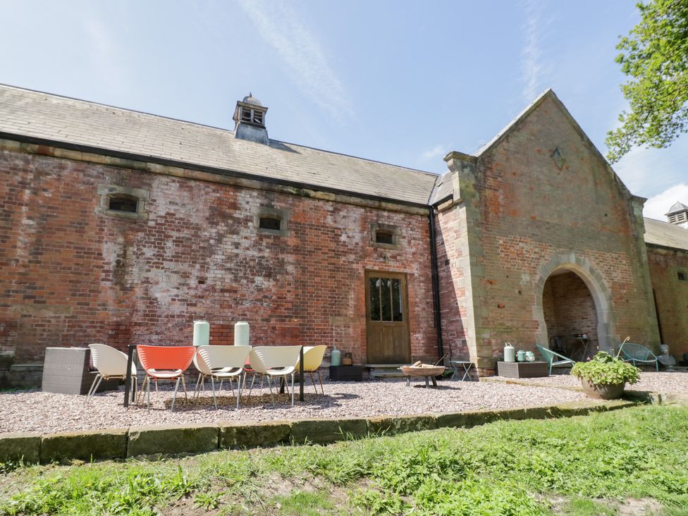 An outdoor area with seating and a brick wall at Talbot Lodge Ingestre near Great Haywood
