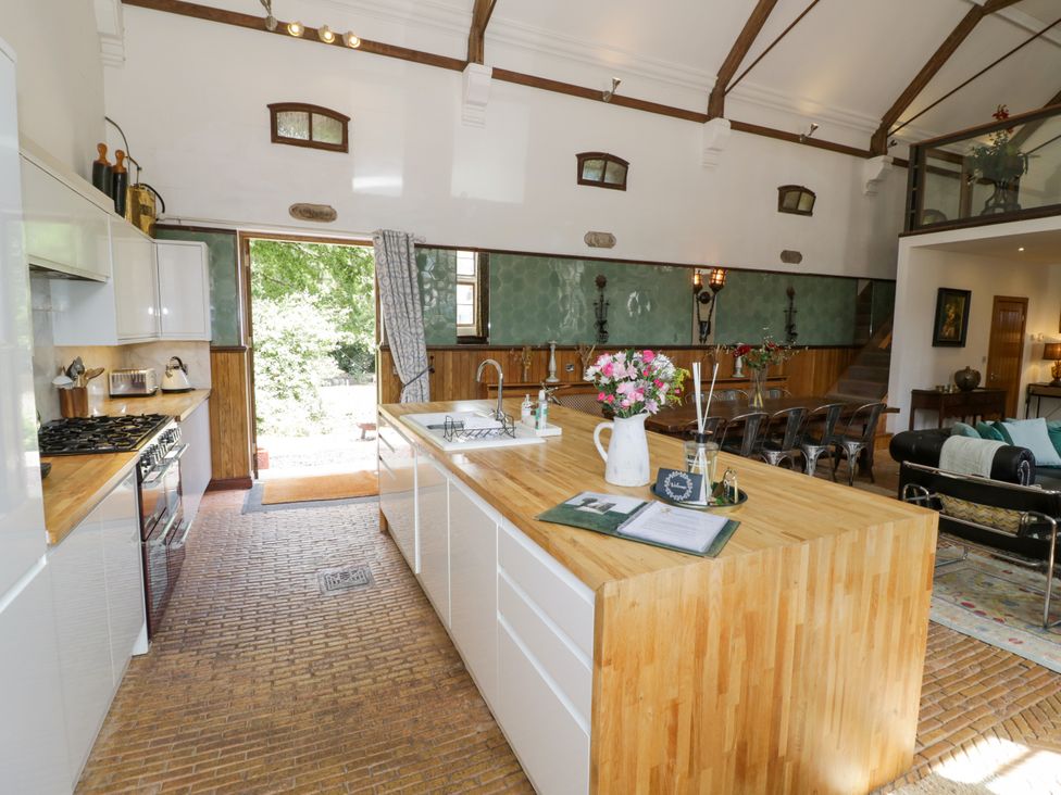 A kitchen with an island and stove at Talbot Lodge Ingestre near Great Haywood