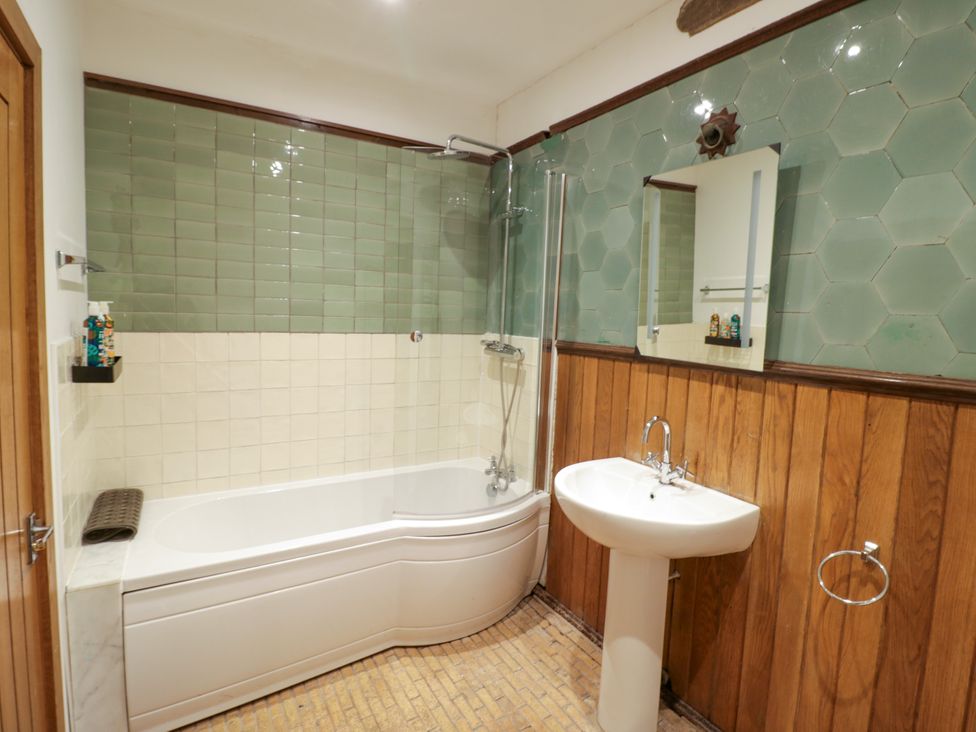 A bathroom featuring a bathtub, shower, sink, and mirror at Talbot Lodge Ingestre near Great Haywood