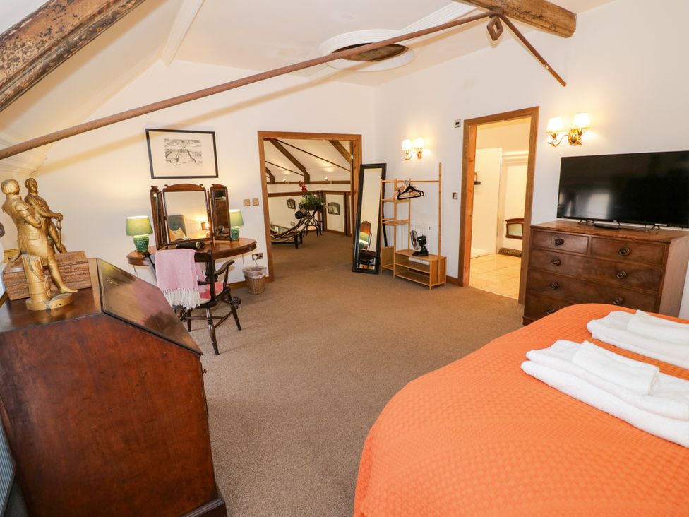 A bedroom with a bed and a dressing table at Talbot Lodge Ingestre near Great Haywood