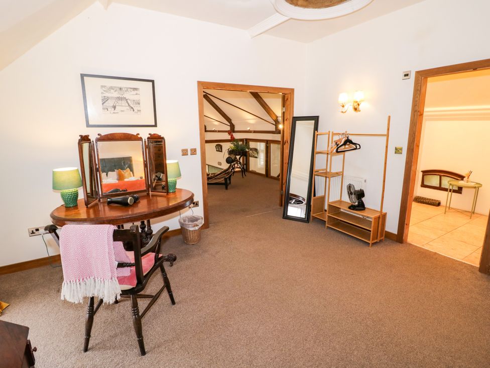 A bedroom with a dressing table and clothes rack at Talbot Lodge Ingestre near Great Haywood