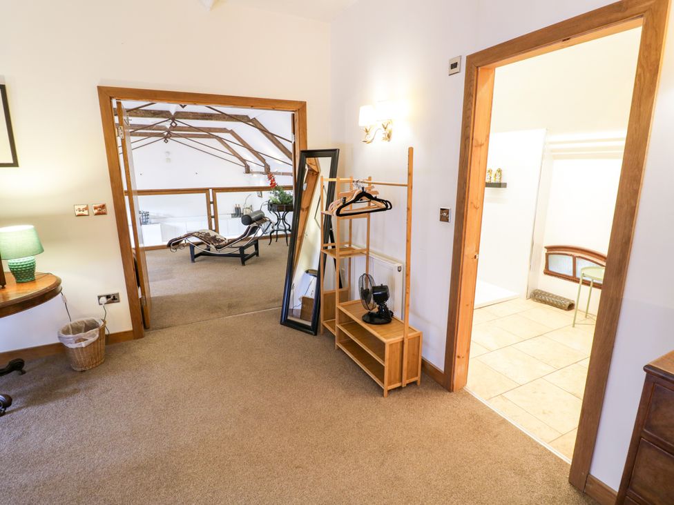 A bedroom with a mirror and coat rack at Talbot Lodge Ingestre near Great Haywood