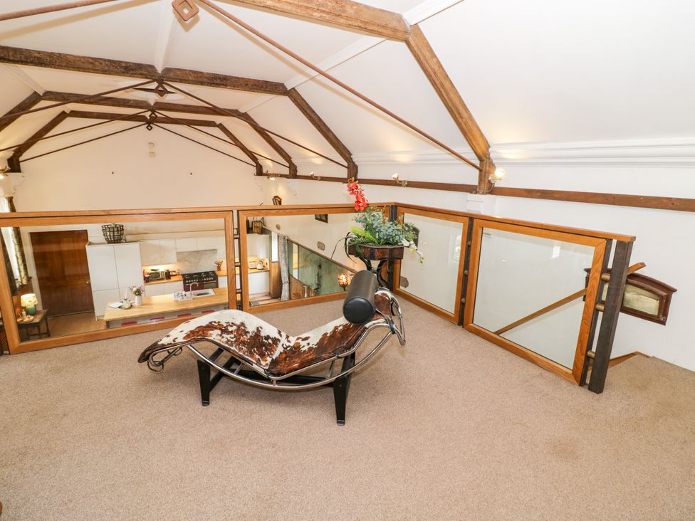 A loft area with a chaise lounge and kitchen furnishings at Talbot Lodge Ingestre near Great Haywood