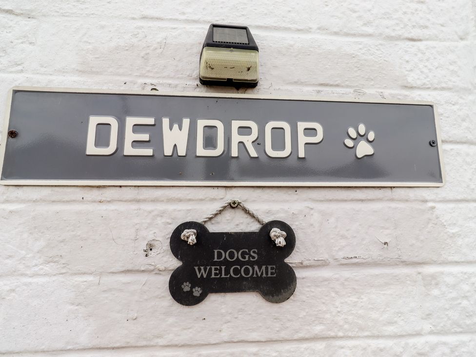 A nameplate and welcome sign mounted on a wall at 22 Longstone Park Beadnell