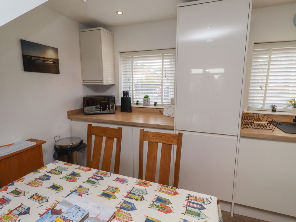 A kitchen with a dining table and chairs at 22 Longstone Park Beadnell