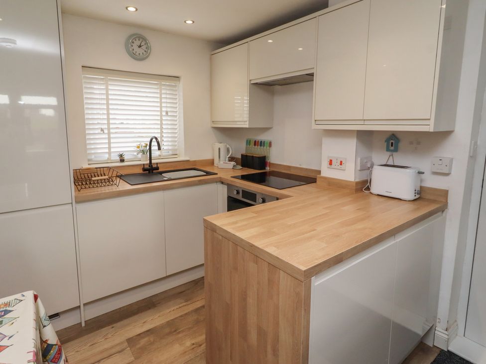 A kitchen with a countertop, sink, and stove at 22 Longstone Park Beadnell