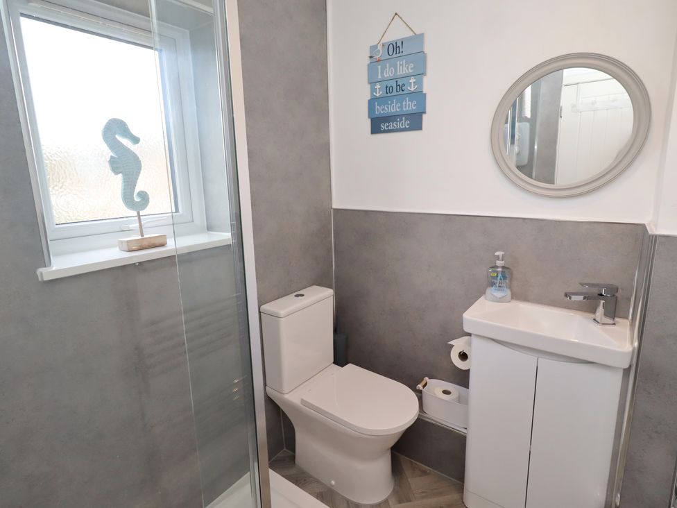 A bathroom with a toilet, sink and shower at 22 Longstone Park in Beadnell