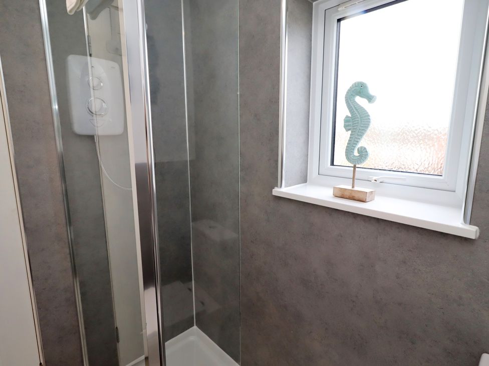 A bathroom featuring a shower and seahorse decoration at 22 Longstone Park Beadnell