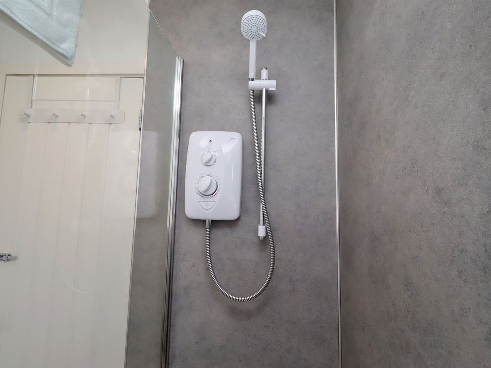 A shower with a shower head and control unit at 22 Longstone Park Beadnell