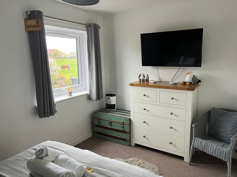 A bedroom with a dresser and television at 22 Longstone Park Beadnell