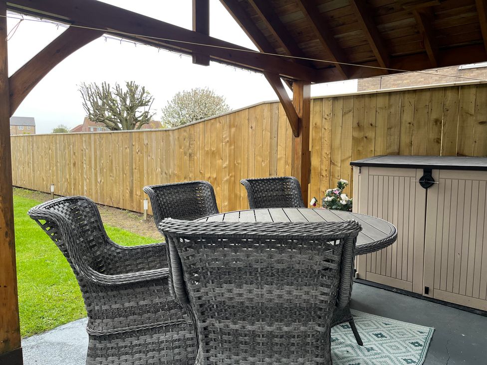 An outdoor patio with a table and chairs at 22 Longstone Park Beadnell