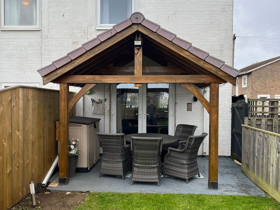 An outdoor patio with a table and chairs at 22 Longstone Park Beadnell