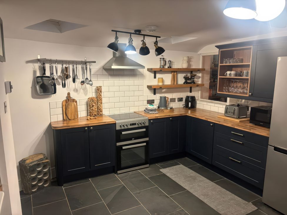 A kitchen with cabinets and appliances at Heol Madog in Porthmadog