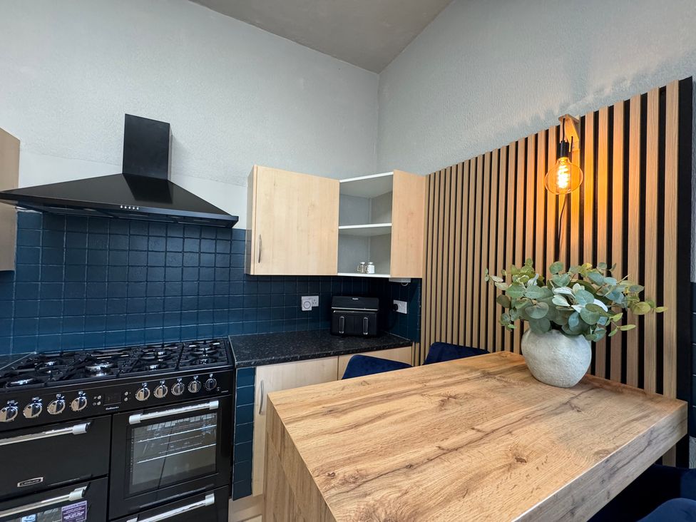 A kitchen with appliances and wooden table at The Causeway
