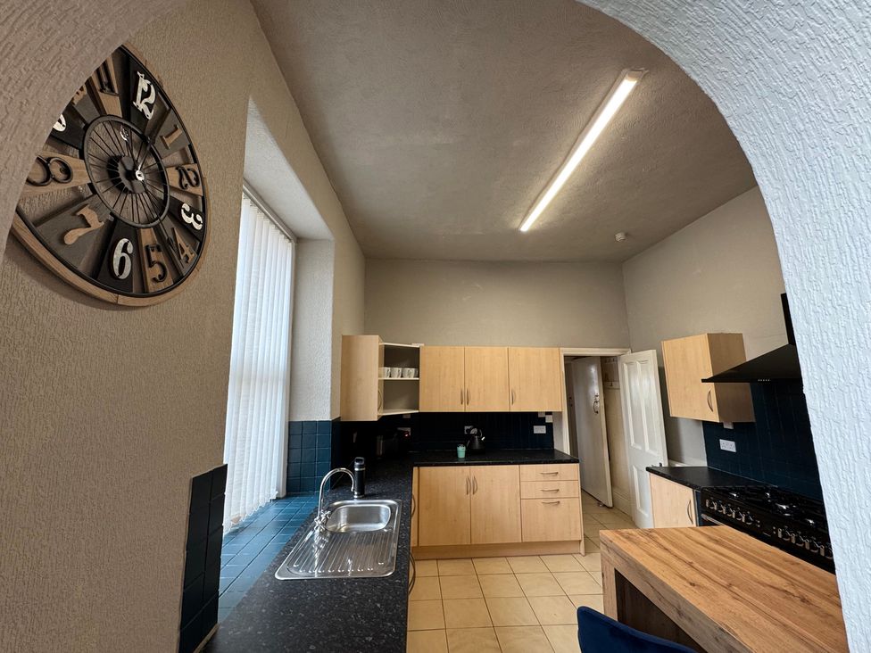 A kitchen with cabinets and a clock at The Causeway
