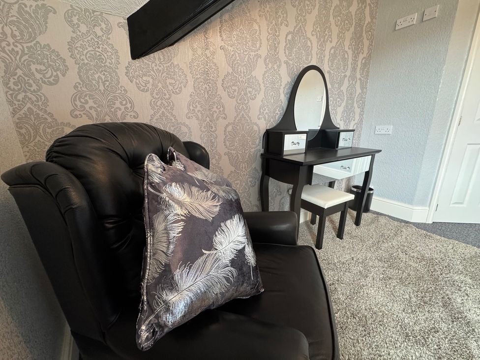 A bedroom with an armchair and a vanity unit at The Causeway 