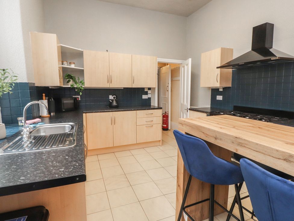 A kitchen with cabinets and appliances at The Causeway in Llandudno