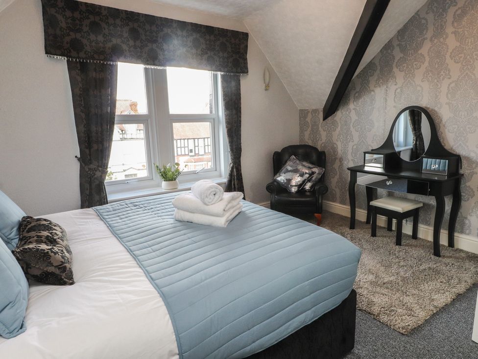 A bedroom with a bed and vanity table at The Causeway in Llandudno