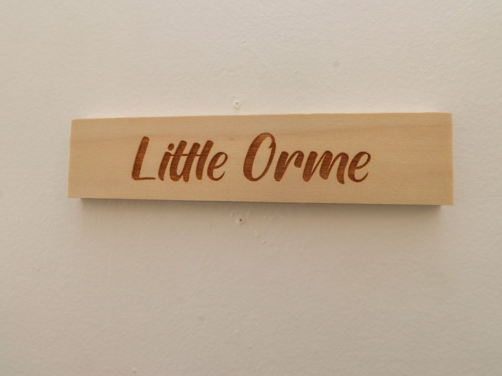 A wooden sign engraved with the words 'Little Orme'