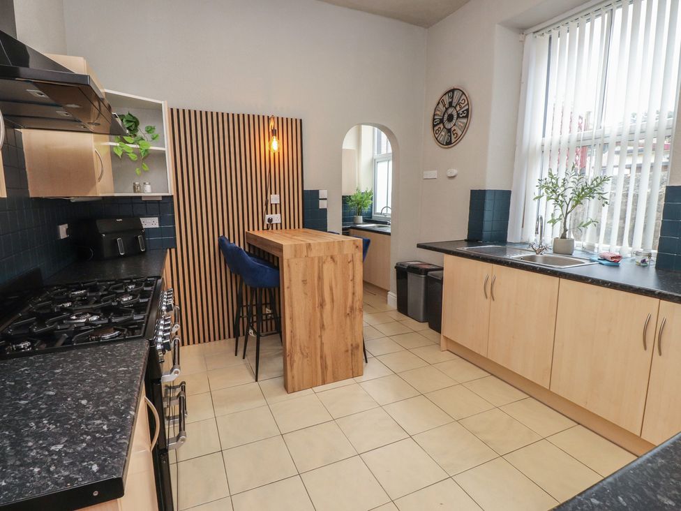A kitchen with a countertop and stools at The Causeway in Llandudno