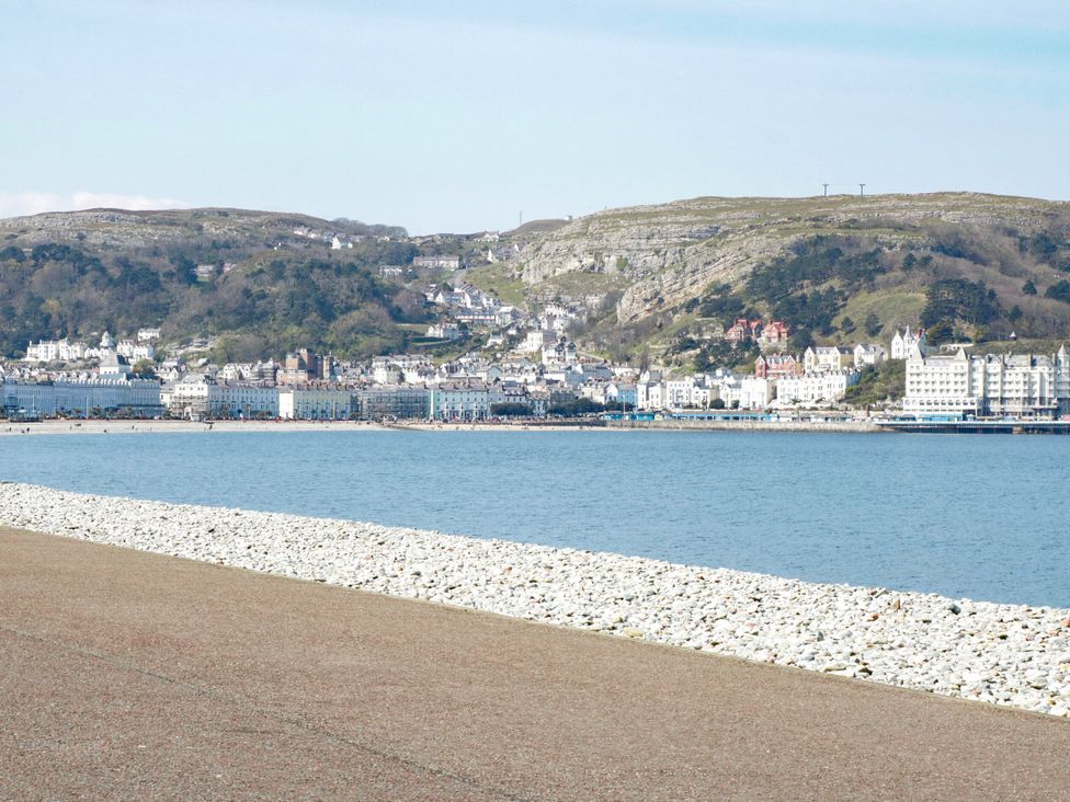 A view of buildings along the shoreline with water at The Causeway in Llandudno