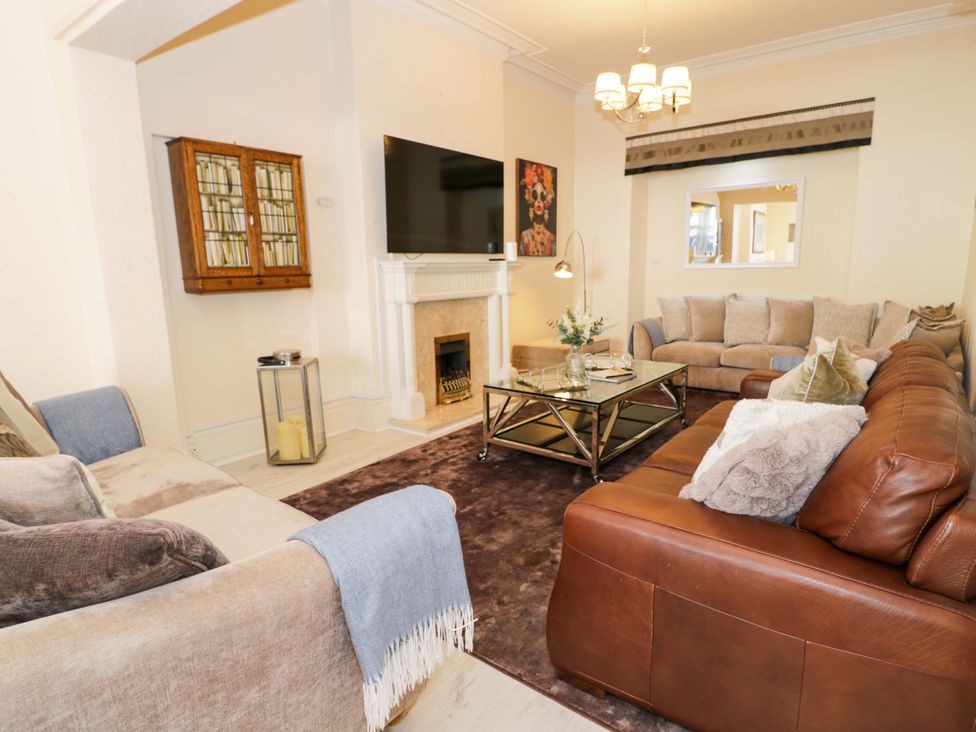 A living room with a sofa, coffee table, and television at The Causeway in Llandudno