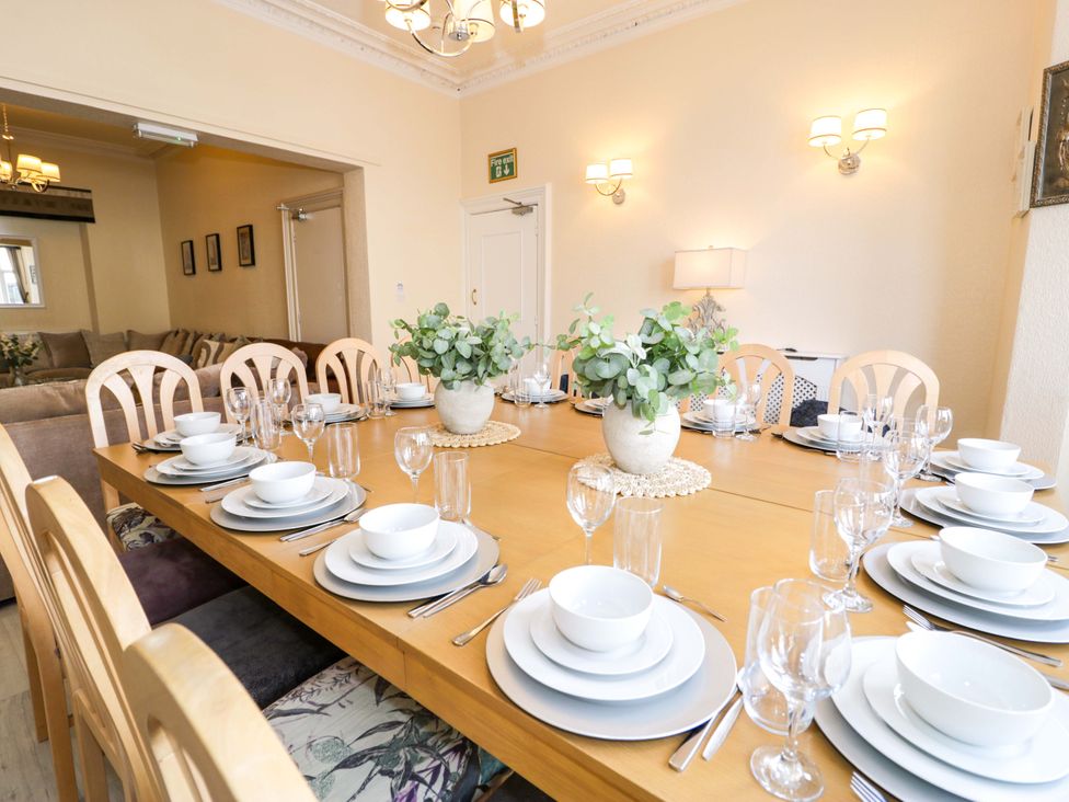 A dining room with a large table set for a meal at The Causeway in Llandudno