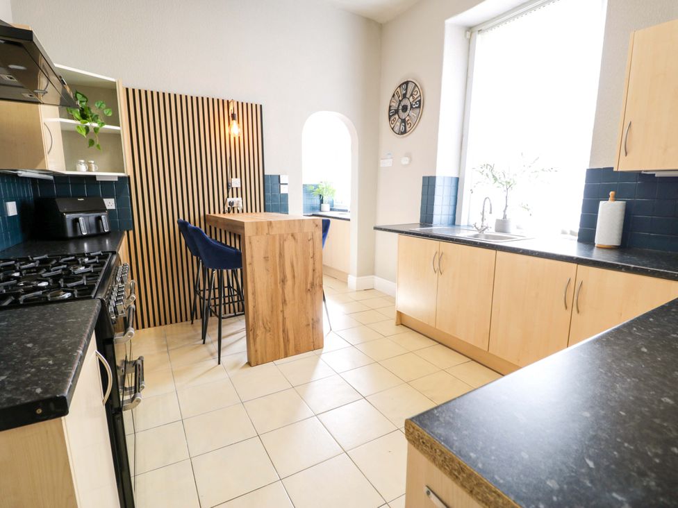 A kitchen with a stove and a kitchen island at The Causeway in Llandudno
