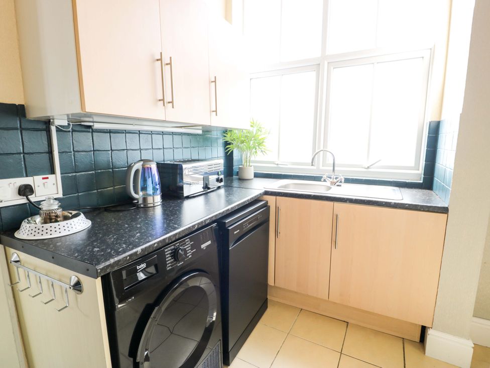 A kitchen with a kettle, toaster, and washing machine at The Causeway in Llandudno