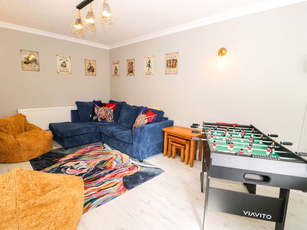 A living room with a sofa and foosball table at The Causeway in Llandudno