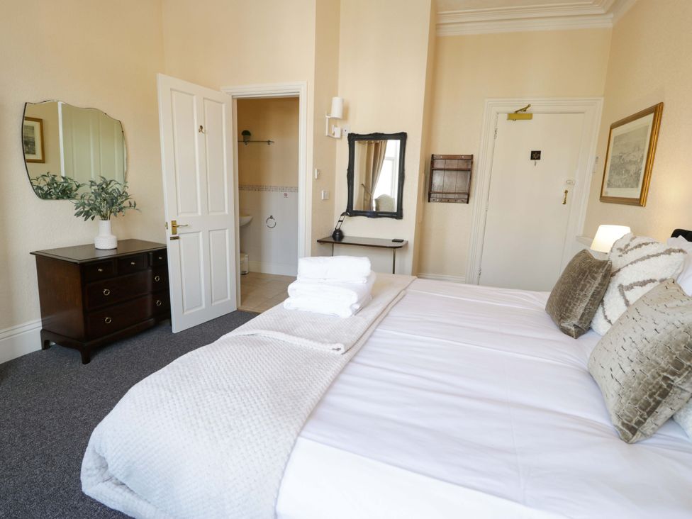 A bedroom with a bed and mirror at The Causeway in Llandudno