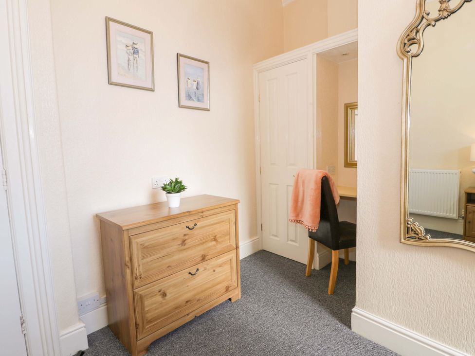 A bedroom with a dresser and a mirror at The Causeway Llandudno