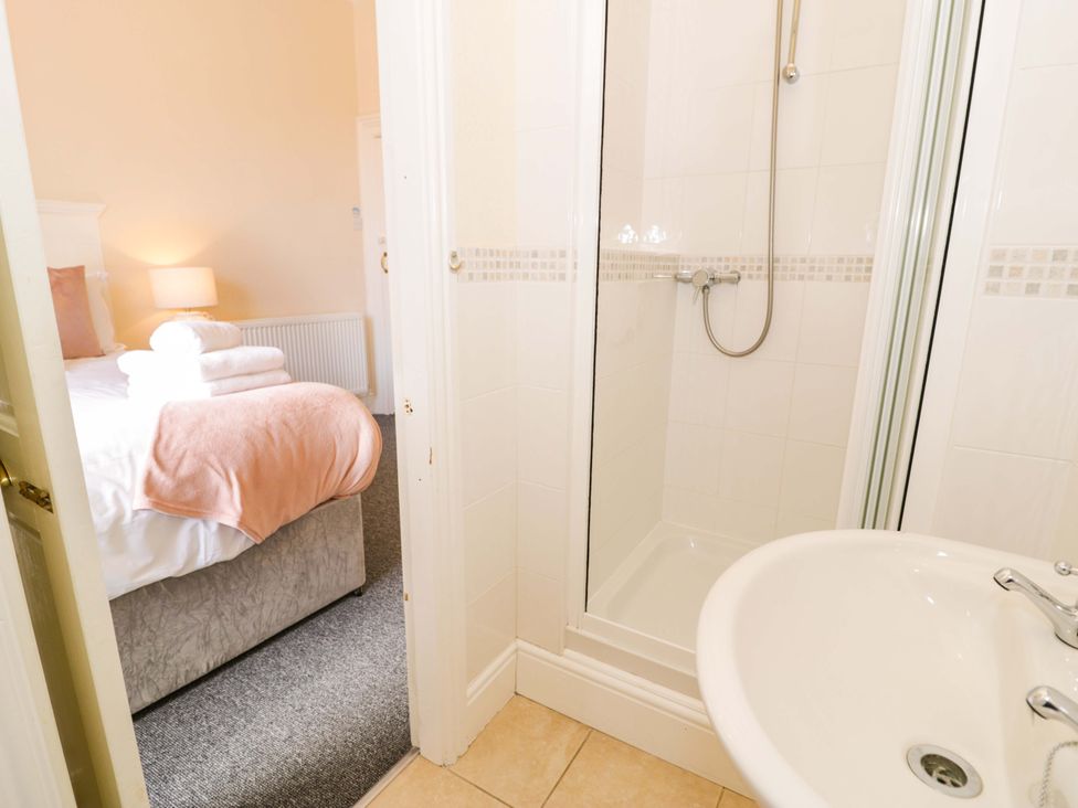 A bedroom with a bed and a bathroom area at The Causeway in Llandudno