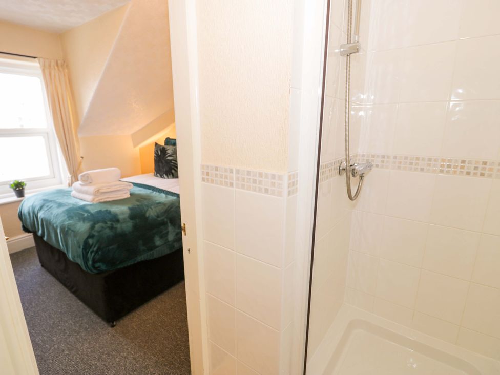 A bedroom with a bed and shower at The Causeway in Llandudno
