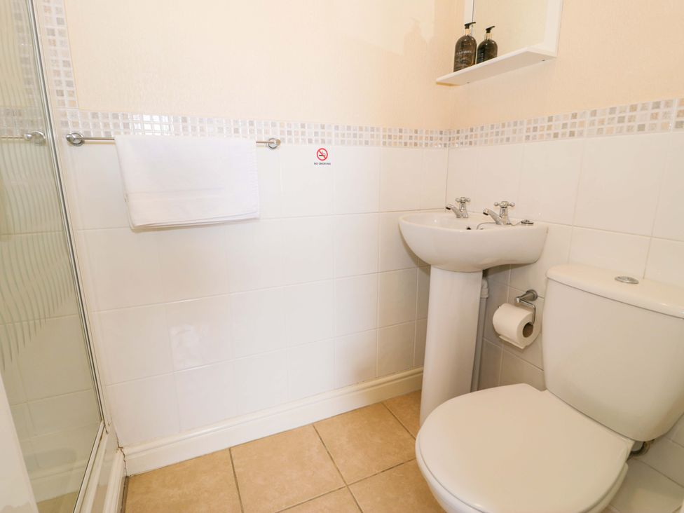 A bathroom with a shower, sink, and toilet at The Causeway in Llandudno