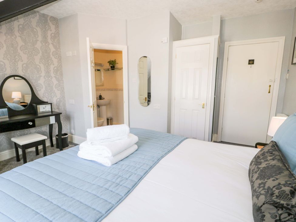 A bedroom with a bed and a vanity table at The Causeway in Llandudno