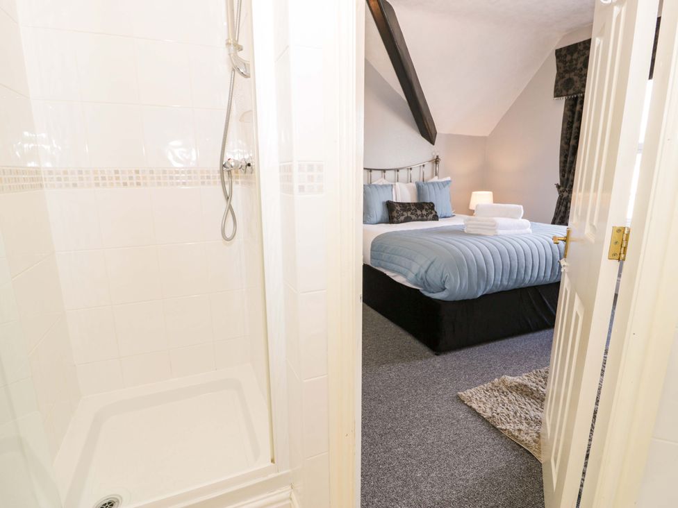 A bedroom with a bed and shower at The Causeway in Llandudno