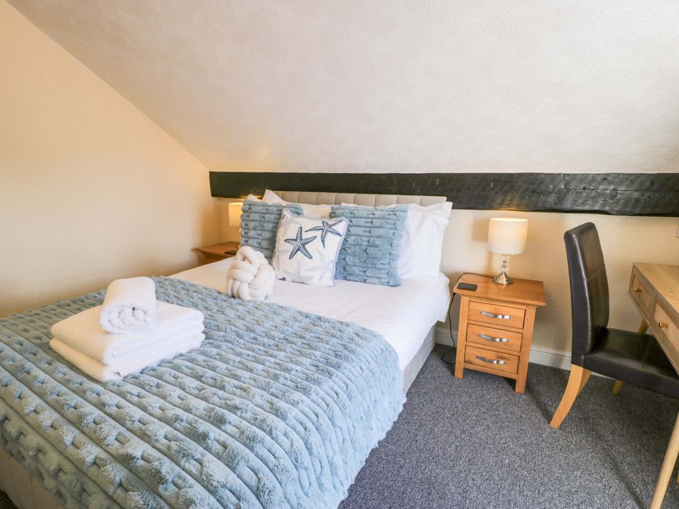 A bedroom with a bed and desk at The Causeway in Llandudno