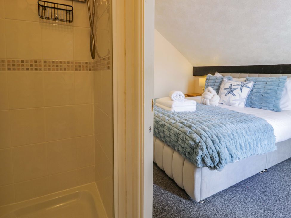 A bedroom with a bed and shower at The Causeway in Llandudno