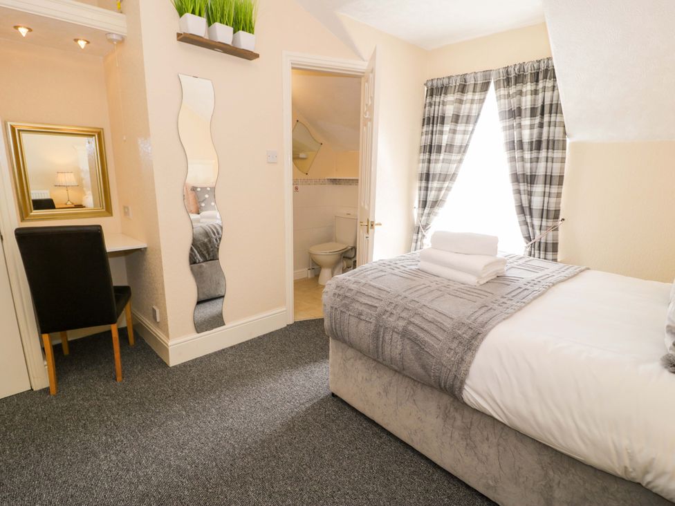 A bedroom with a bed and desk in The Causeway Llandudno